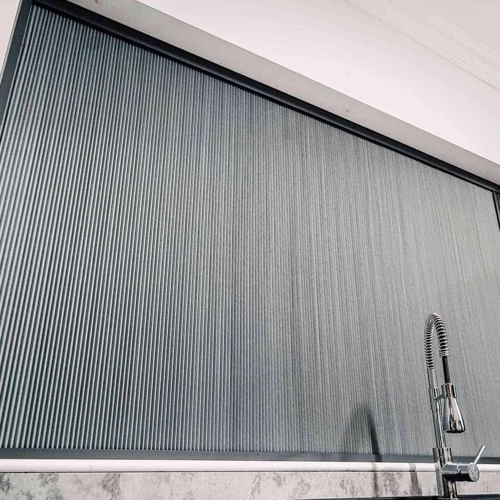 Blind Screen® installed in a kitchen window with dark pleated fabric closed for privacy.