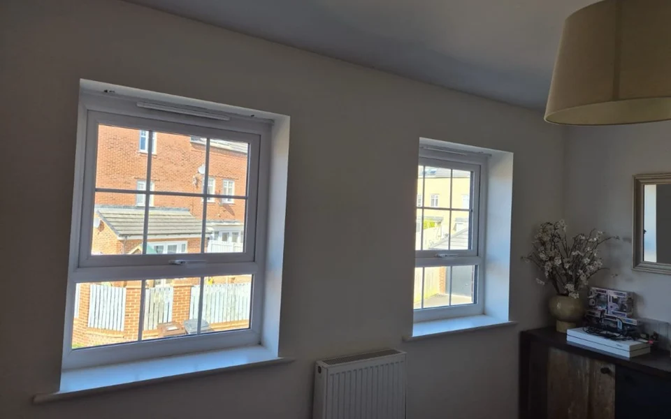 Twin white-framed bedroom windows in a Bradford home suited to plantation shutters.
