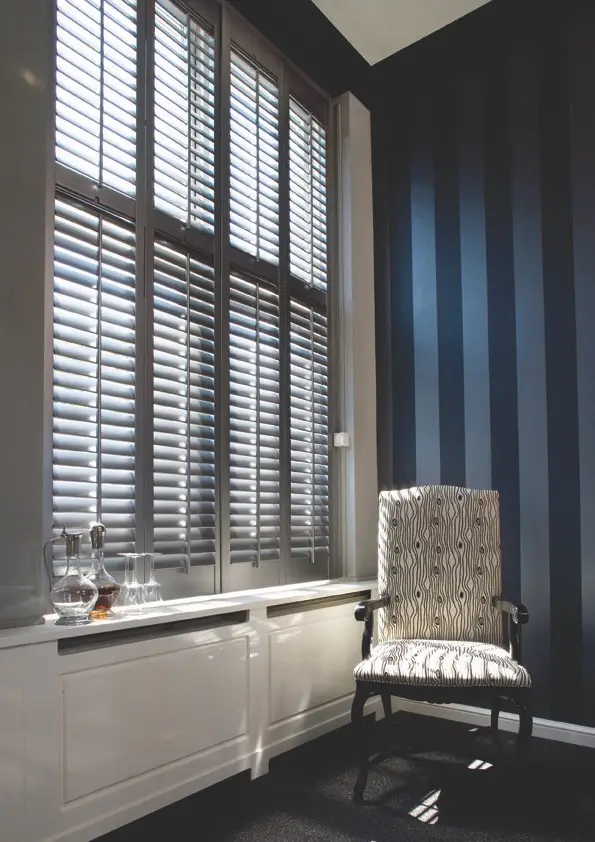 Full-height plantation shutters in a Rawdon stone lounge