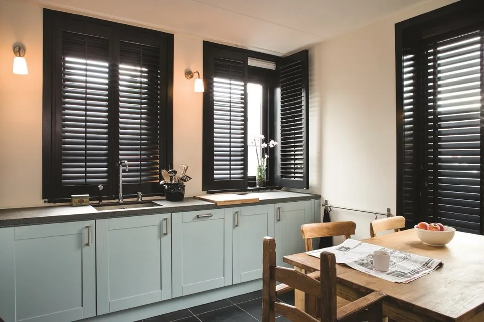 Full height shutters covering tall kitchen windows.