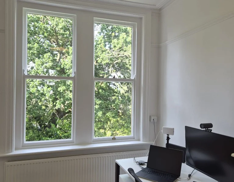 Harrogate home office with a large white-framed sash window before shutters were installed.