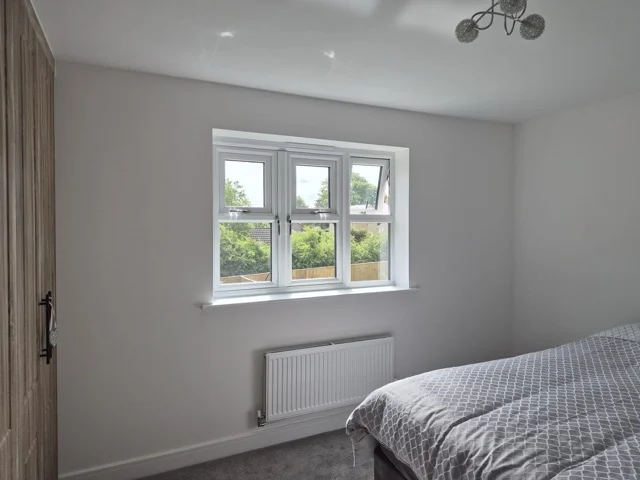 Otley bedroom with a three-pane window before plantation shutters were installed.