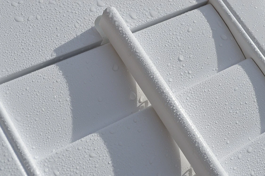 Close-up of white Java ABS shutters with water droplets on the louvres — fully waterproof.