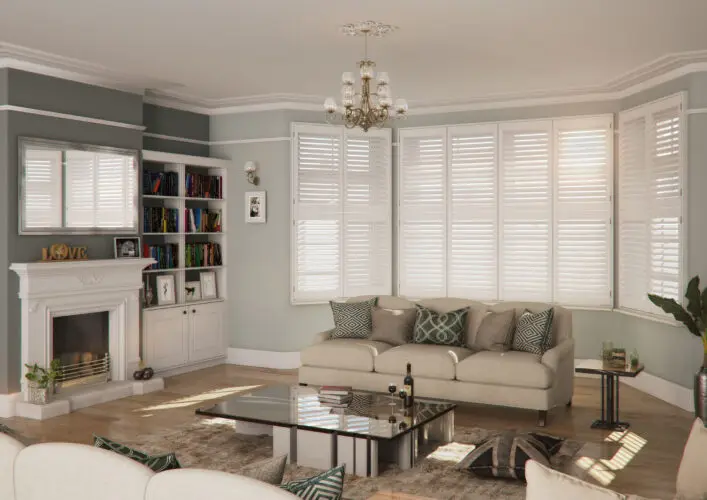 White plantation shutters in a Yorkshire living room with sofa and natural daylight.