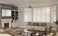 White plantation shutters in a Yorkshire living room with sofa and natural daylight.