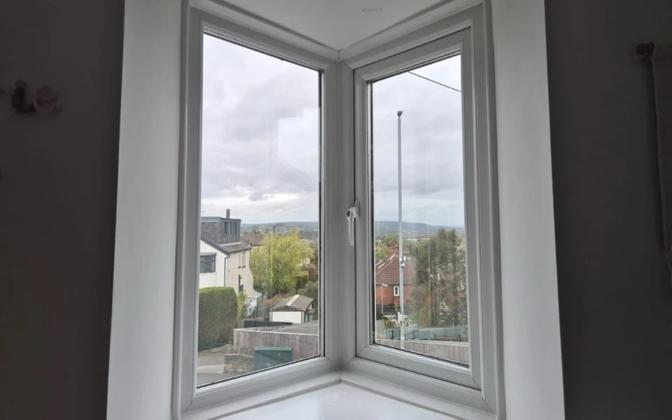 Before: angled V-shaped window in a Rawdon nursery with white uPVC frames, prior to shaped shutter installation.