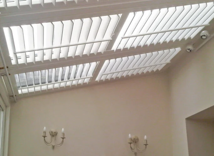 Ceiling-mounted skylight shutters in a high-level room.