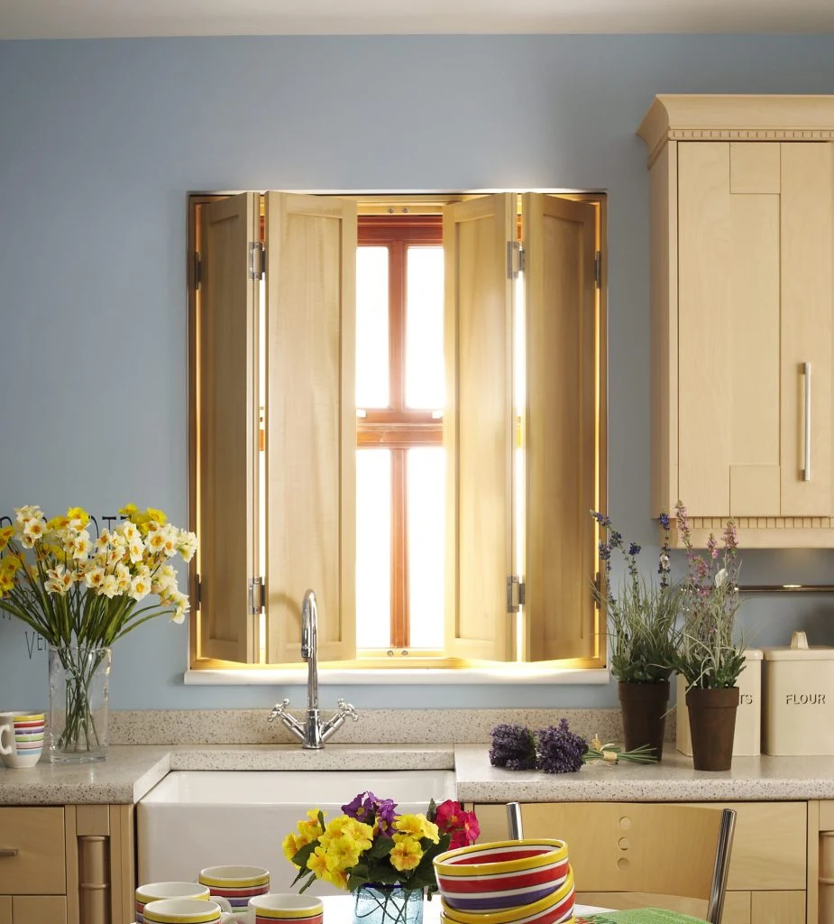 Natural timber solid panel shutters in a bright kitchen.