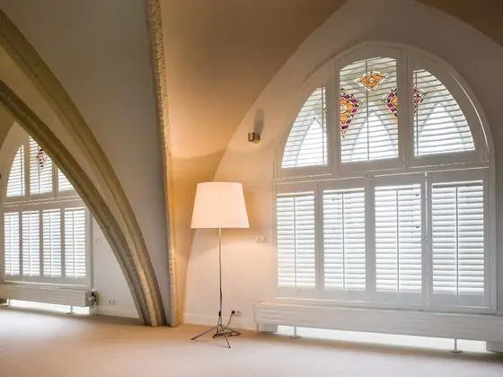 Special shaped shutters on an arched window.