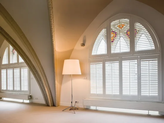 Special shaped shutters on an arched window.