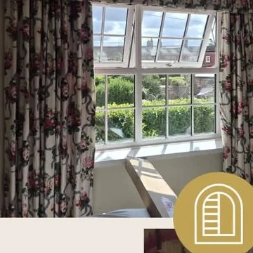 Wakefield bedroom window before shutters, floral curtains and valance with bare lower glass and top panes tilted open.