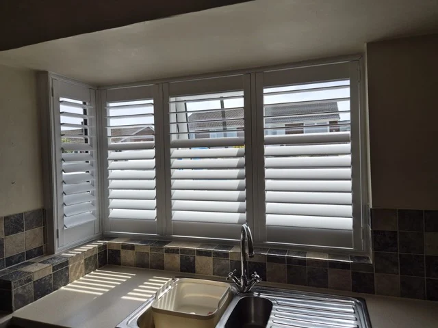 Wakefield kitchen after white plantation shutters were fitted to the corner window above the sink.