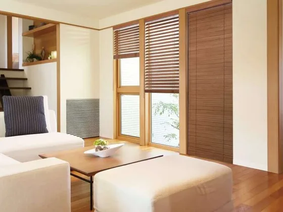 Natural wooden venetian blinds in a bright room.