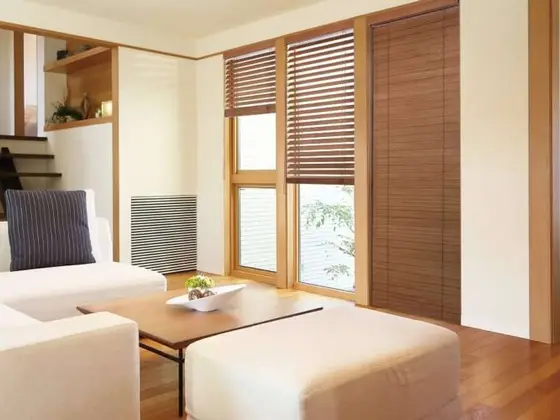 Natural wooden venetian blinds in a bright room.