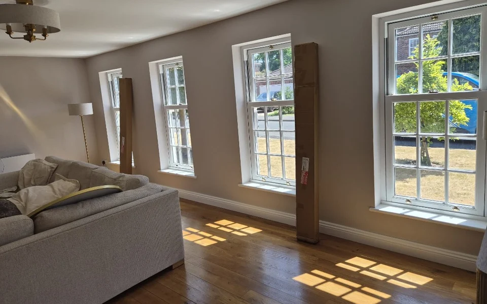 York lounge before shutters, four matching white Georgian-pane sash windows with shutter packaging leaning against the wall.